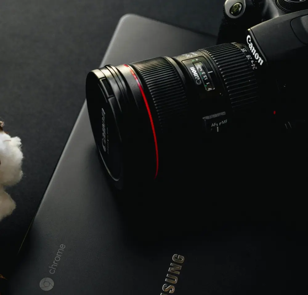 Canon camera resting on a closed samsung tablet