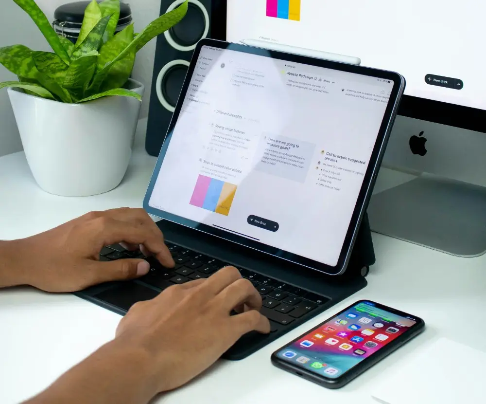 Tablet being used as a laptop with an iphone sitting on a desk