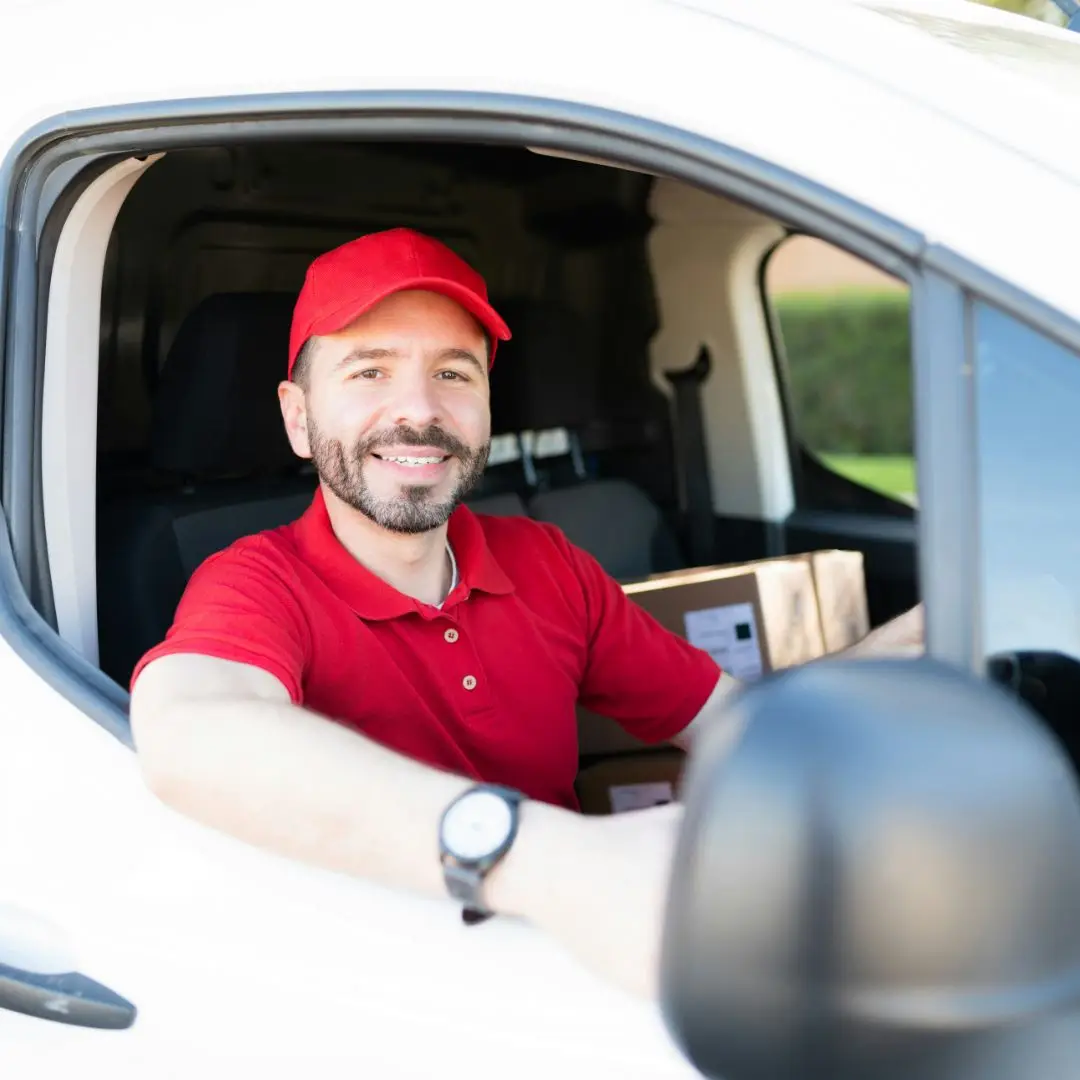 Smiling courier leaning out of van